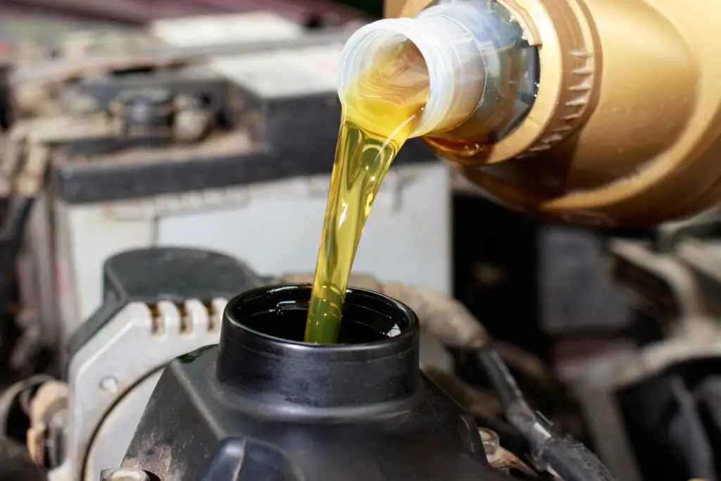 The car maintenance master pours engine oil for the car engine.