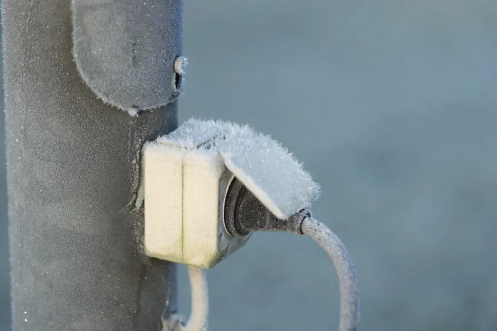 Close up of plug and electric outlet in a winter day