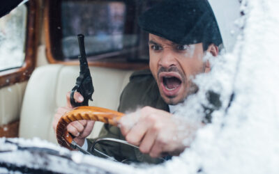 Angry man with a pistol inside old car