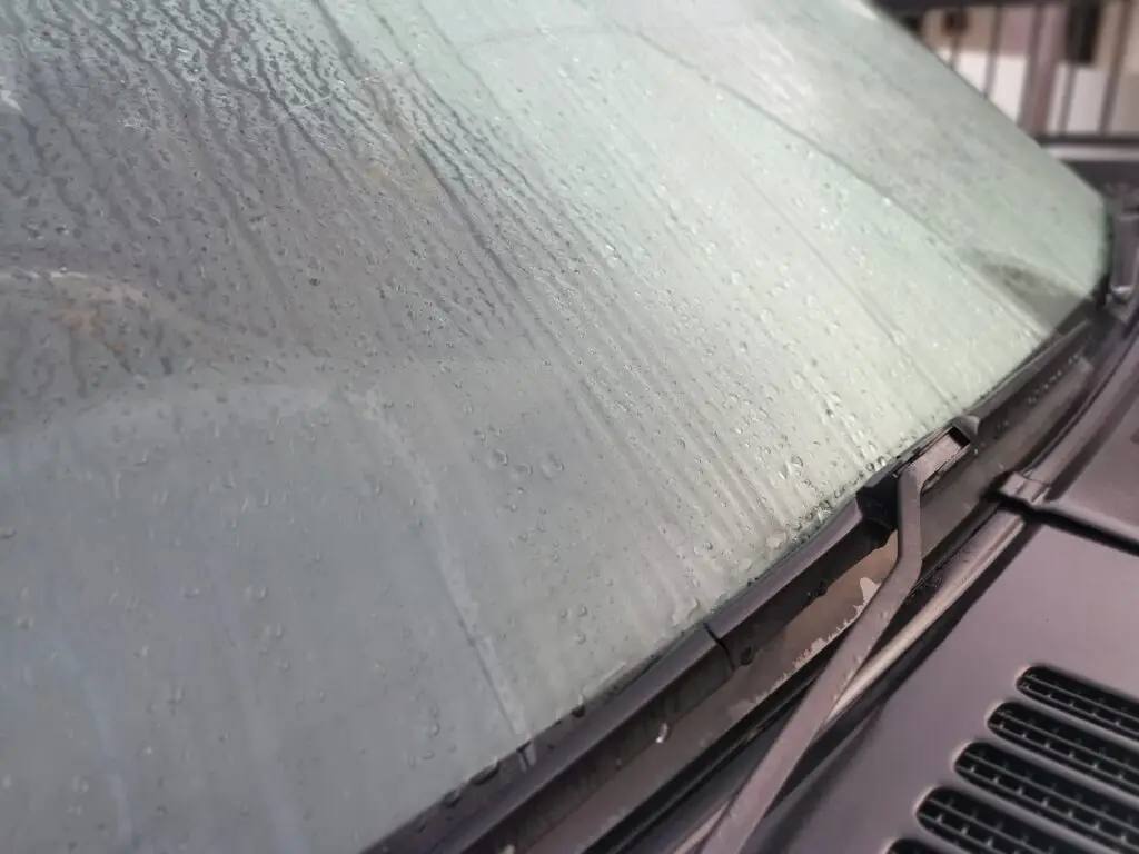 Vehicles windshield is covered with fog outside. Misty morning.