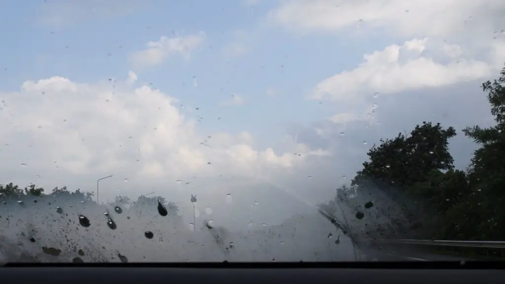 Car is driving on the highway with fogged windshield from the inside. Bad visibility.