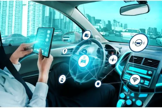 Concept of futuristic car, person in a car reading news on tablet while vehicle is driving by itself.
