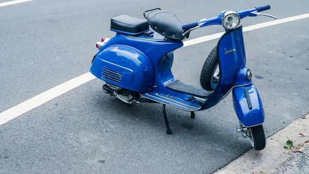 Blue vintage moped parked on the road