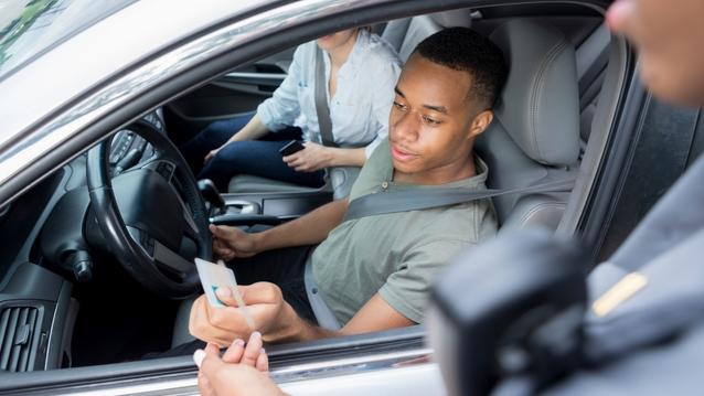 Man is pulled over by police officer for car registration check.