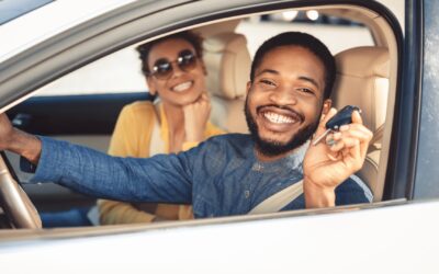 Two People Sit in a Car and Smile
