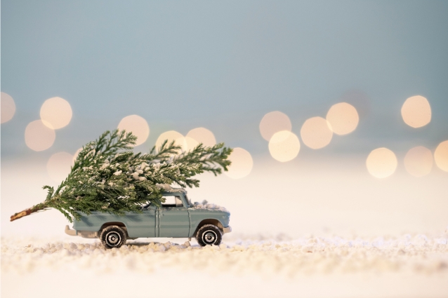 Little toy car with toy Christmas three on it's roof. Christmas holiday representation. 